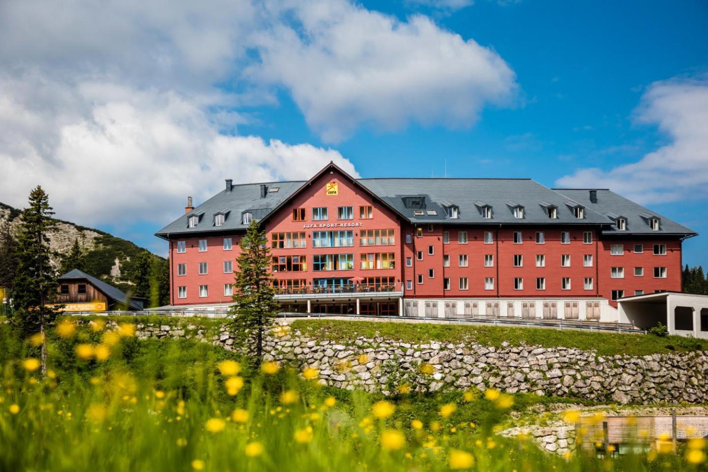 Hochkar Bergbahnen in Austria: a red building with yellow flowers in front of it.