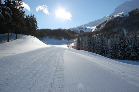 Winter sports scene in Campitello Matese Italy featuring a chalet nestled amidst snowy surroundings and a skier heading towards a winter sports center.