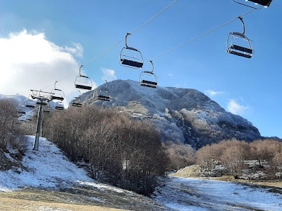 A spectacular view of Campitello Matese in Campobasso, Italy, featuring a ski lift amidst a scenic winter landscape at a ski resort, indicative of active winter sports.