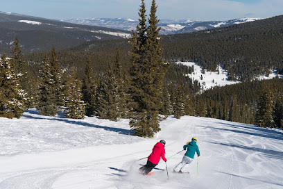 A family and group of people enjoying a day of skiing at the Cooper ski resort in Leadville Colorado. The winter sports scene is full of activity amidst a beautiful snowy landscape.
