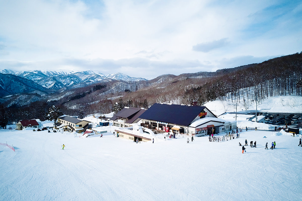Hodaigi Ski Resort in Japan - a group of people skiing down a snowy slope.