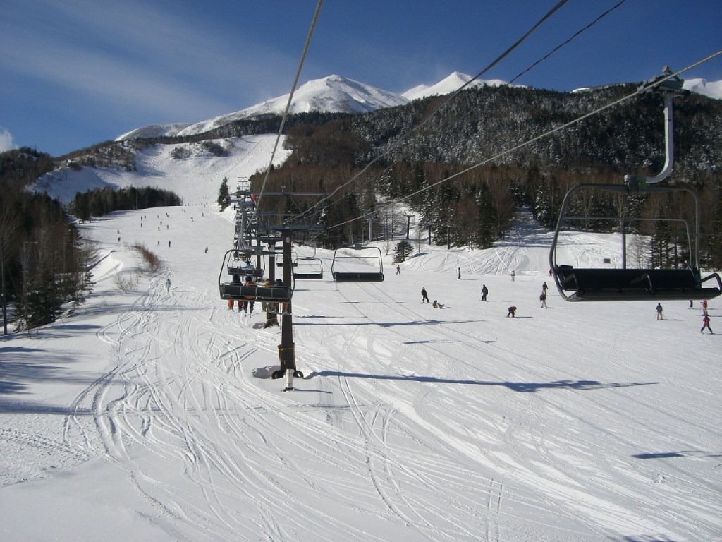Norikura in Japan - a ski slope with people skiing down it.