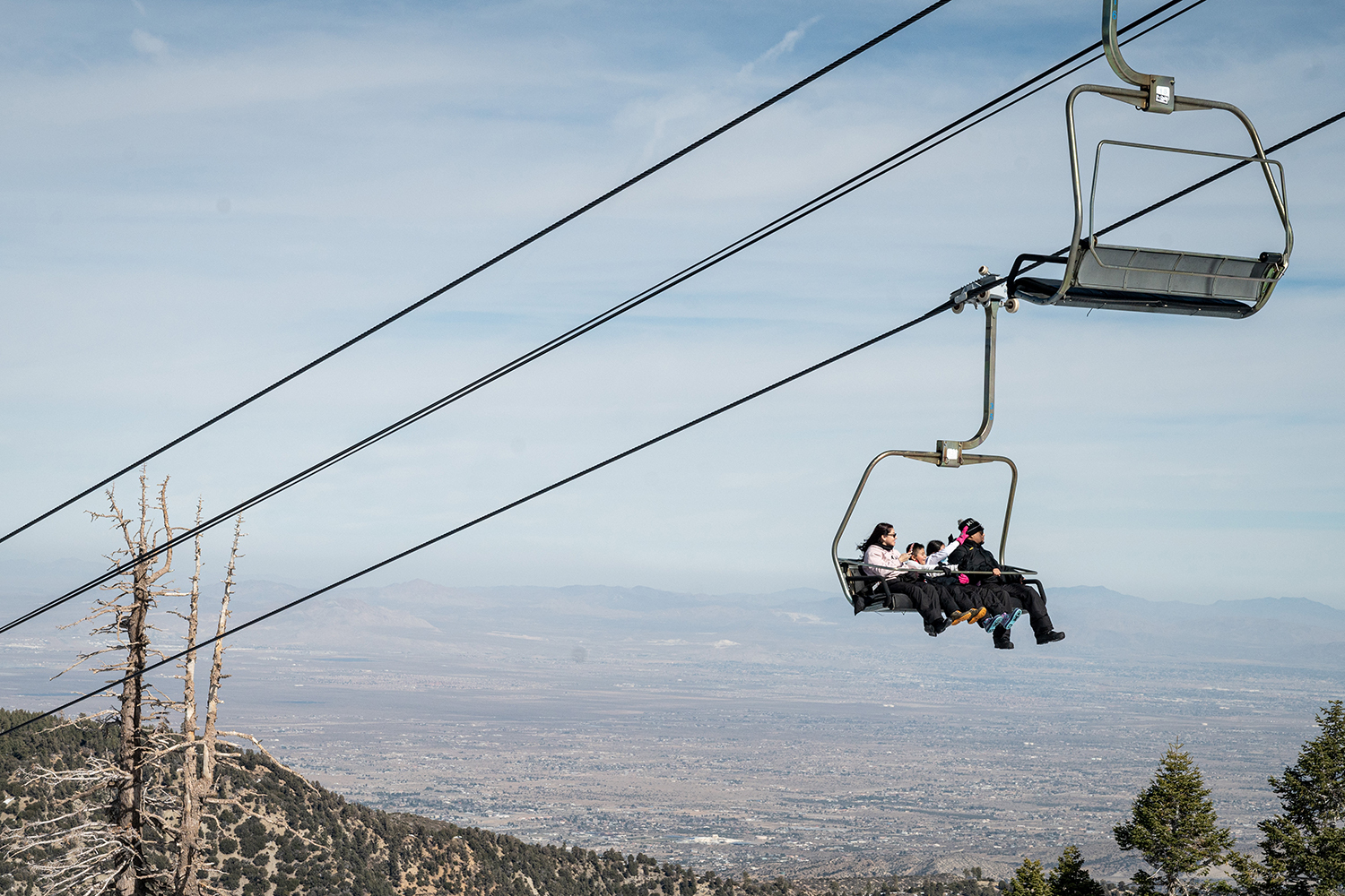 Mt. High East in USA - two people sitting on a chair on a ski lift.
