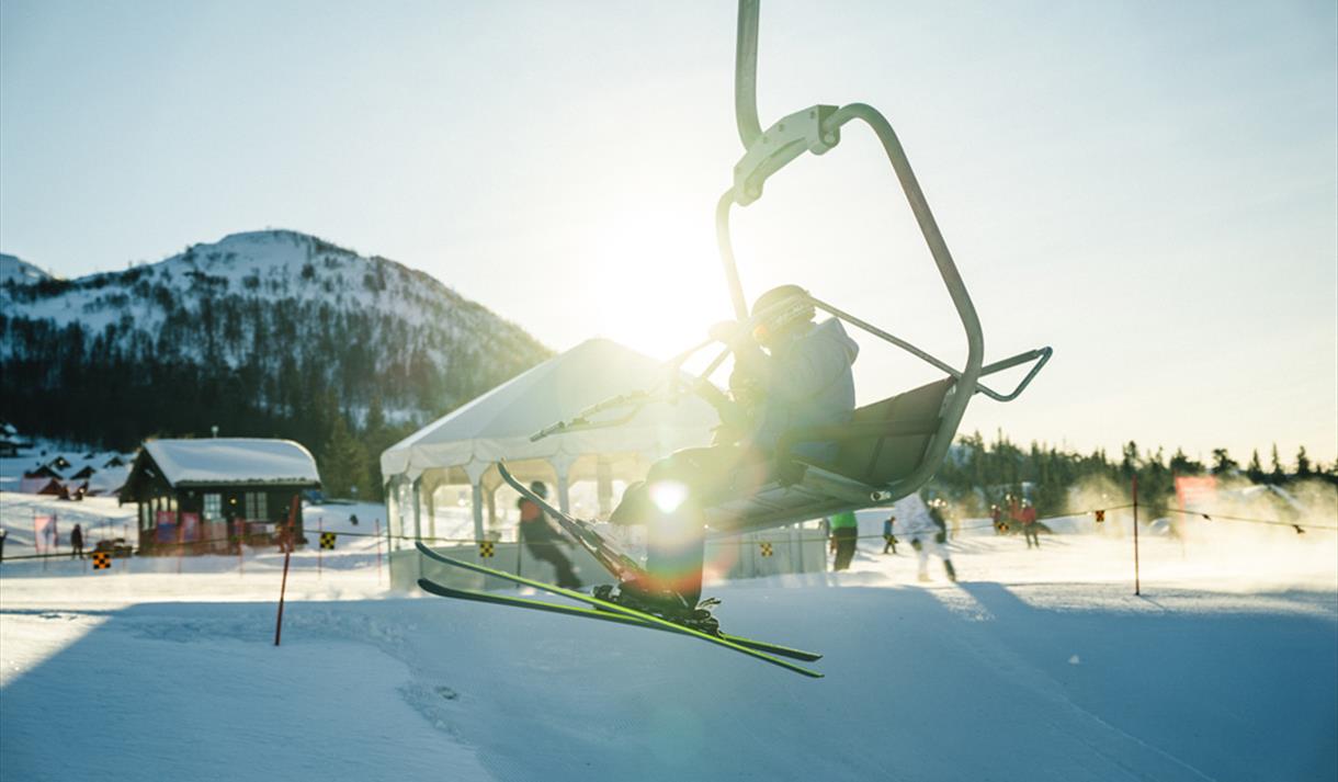 Rauland Skisenter in Norway - a skier on a ski lift in the sun.