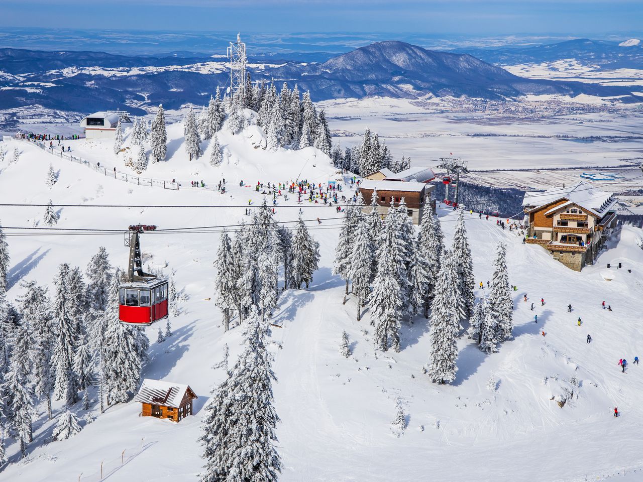 Poiana Brasov in Romania: a ski resort surrounded by snow covered trees.