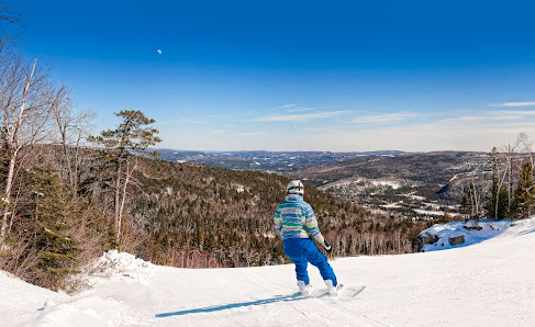 A snowboarder in action at Val Saint-Come in Lanaudière, Saint-Côme, Quebec, Canada, showcasing the thrilling winter sports scene of the region.