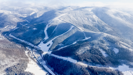 Winter scene at Kouty nad Desnou in Loučná nad Desnou, Czech Republic, featuring a bustling ski resort with skiers enjoying the snow-covered slopes amidst stunning winter scenery.