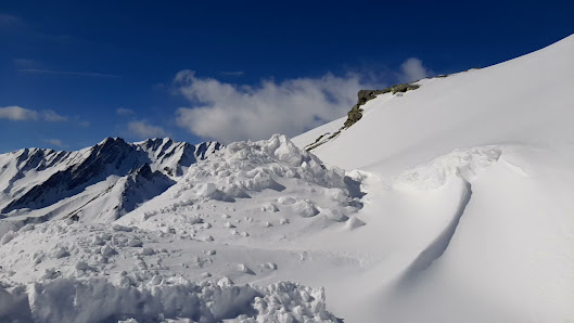 Winter sports enthusiasts enjoying a day on the snow-covered slopes of Crévacol in Great Saint Bernard, Saint-Rhémy-en-Bosses, Aosta, Italy. Mountain peaks and a chalet complete the picturesque scene.