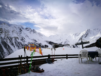 A delightful winter scene at Crévacol in Italy showcasing the bustling activities at a ski resort. Amidst the serene winter scenery skiers glide down the snow-covered slopes with joy.