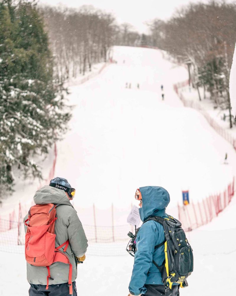 Holimont in USA - two people walking in the snow with backpacks.