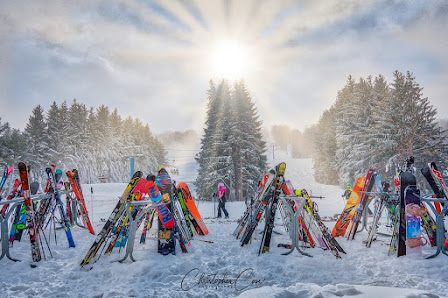 Winter sports scene at Holimont, Chautauqua-Allegheny, New York; featuring a stunning family skiing amidst a picturesque winter panorama at the ski resort.