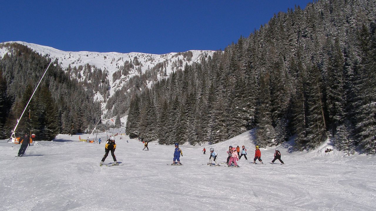 Obertilliach – Golzentipp in Austria - a group of people skiing down a snowy slope.