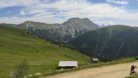 Charming challet nestled in the scenic mountain landscape of Obertilliach in Tyrol, Austria. The scene is completed by hints of a ski resort and a rustic mountain hut.
