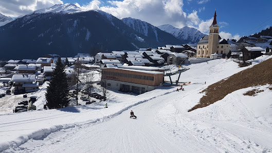 Winter sports scene at Obertilliach – Golzentipp ski resort in Osttirol, Austria, featuring a cozy chalet amidst stunning snow-covered scenery.