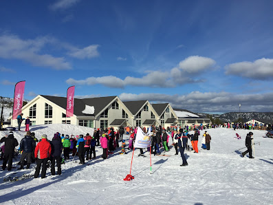 Winter scene at Gautefall Skisenter in Norway, highlighting a bustling ski resort brimming with winter sports enthusiasts, with a charming chalet peeking through in the background.