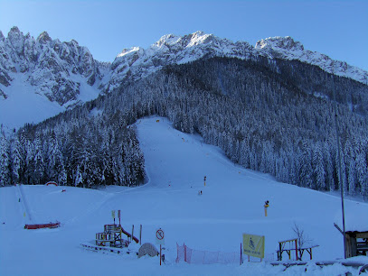 Scenic view of Baranci Piste Da Sci in Italy featuring a ski resort and winter sports center amidst a captivating winter landscape with a cozy chalet in the background.