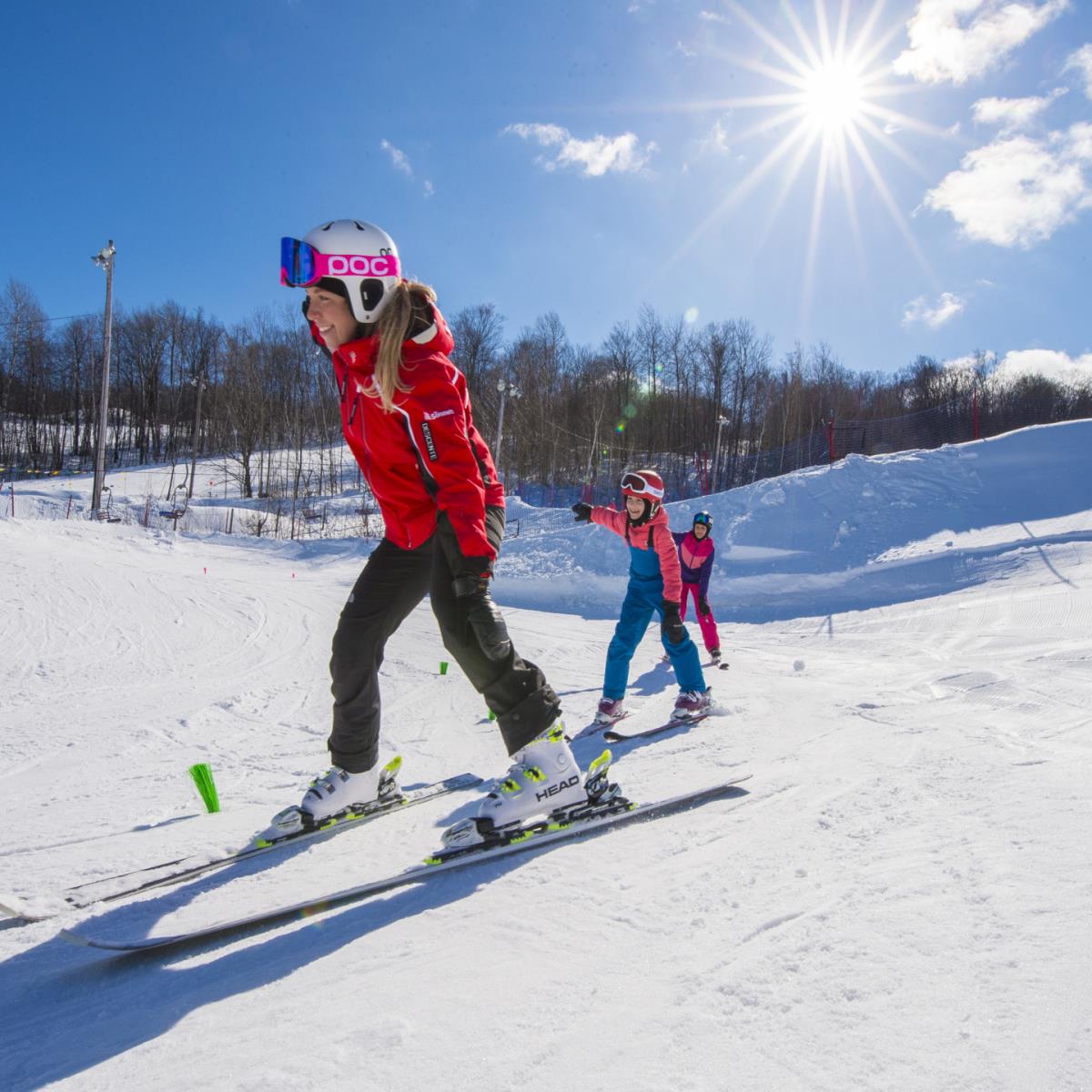 Saint-Sauveur Summit (Versant Avila) in Canada - a woman and child skiing down a hill.