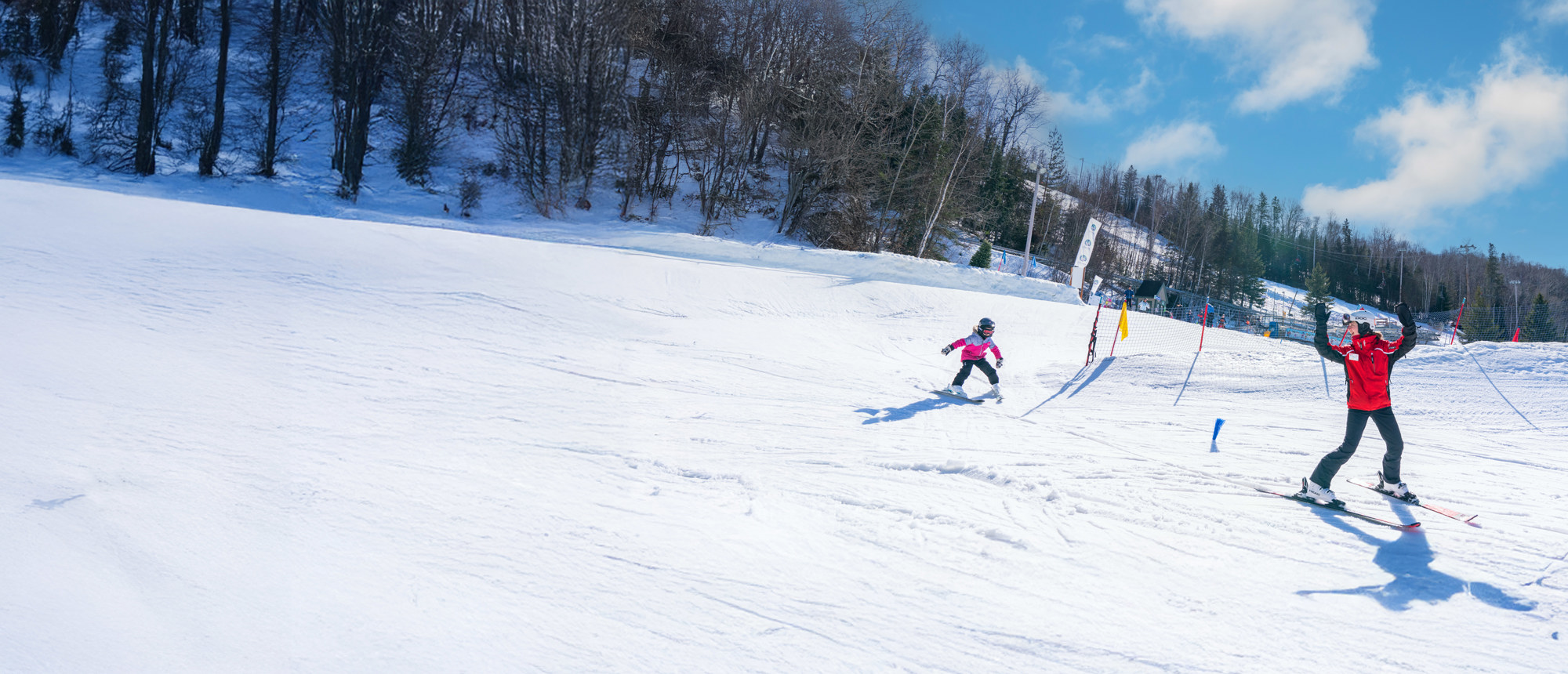 Saint-Sauveur Summit (Versant Avila) in Canada - a group of people skiing down a snowy slope.