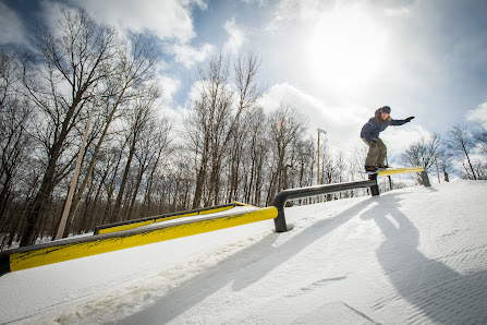 A snowboarder carving through the fresh snow at the beautiful Saint-Sauveur Summit in Piedmont Quebec Canada showcasing the stunning beauty of the Laurentides region during winter.