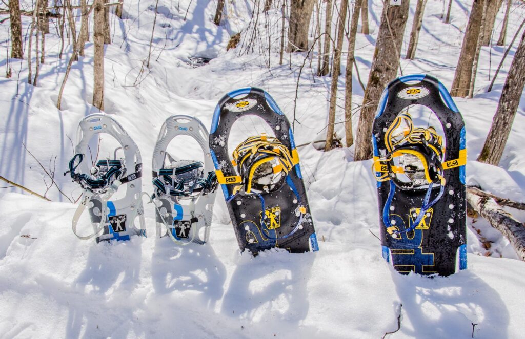 A snowmobile in the forefront at Camp Fortune in Quebec Canada. A winter sports scene unfolds in the background with skiers a ski lift and stunning winter scenery creating a familial atmosphere.
