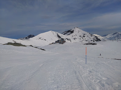 View of San Isidro-Zona Cebolledo featuring a chalet ski resort and a ski lift amidst a bustling winter sports scene in Castile-Leon Spain.