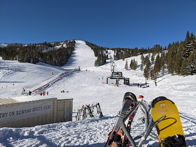 A vibrant winter scene at Showdown ski resort in Neihart Montana featuring a ski lift ascending amidst snow-covered slopes with an active skier embodying the lively atmosphere of the winter sports center.