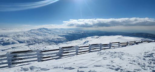 A breathtaking winter panorama in Zaarour, Lebanon showcasing a beautiful snow-covered landscape, a charming chalet, and a bustling winter sports scene.