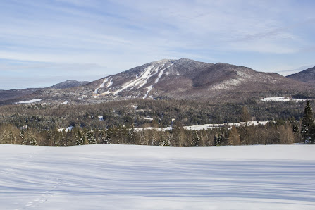 Winter sports enthusiasts enjoying a day on the snow-covered slopes of Burke Mountain ski resort in East Burke, Vermont, showcasing a picturesque winter mountain scenery.