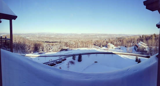 Winter scene at Burke Mountain in East Burke, Vermont, showcasing a vibrant winter sports center, filled with energetic skiers amidst stunning, snow-covered landscapes of the ski resort.