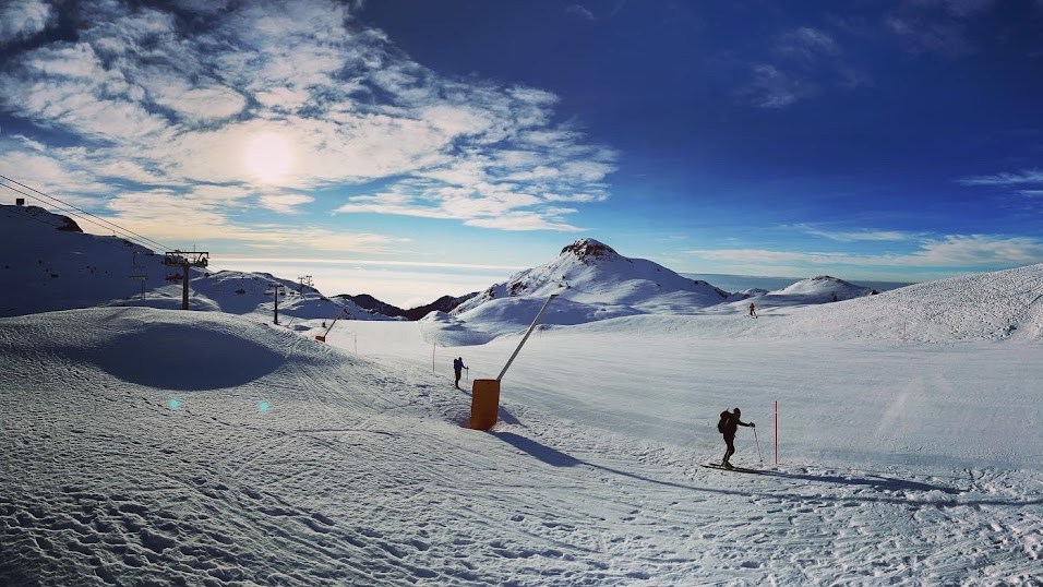 A vibrant winter sports scene unfolding at the ski resort of Piancavallo in Italy. Skiers glide through the snow against a backdrop of serene winter scenery.