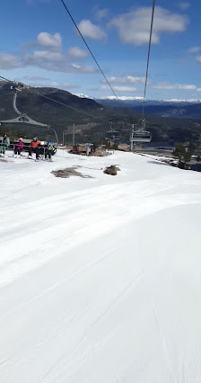 A skier enjoying a run at the Vrådal Panorama ski resort in Telemark, Norway, with a ski lift and chalet under a crisp winter sky.