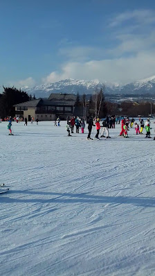 Winter sports in action at Ancelle, France, featuring a bustling ski resort with skiers on the snowy slopes, and a charming chalet nestled amidst the picturesque winter landscape.