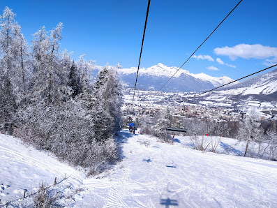 Winter picture from Ancelle, France, showcasing a bustling ski resort, complete with a ski lift dominating the landscape, amidst a beautiful snowy scenery dominated by a charming chalet.