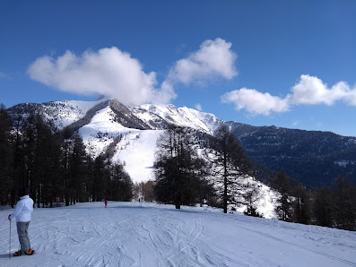 A charming chalet amidst a lively winter sports scene at the mountain base featuring a skier in Ancelle a popular ski resort in Hautes-Alpes France.