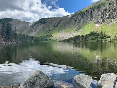 A pristine view of the Red River in New Mexico USA featuring a sparkling lake with a mountain's majestic silhouette in the background.