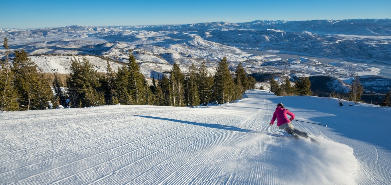 Deer Valley in USA - a person skiing down a snowy slope in the mountains.
