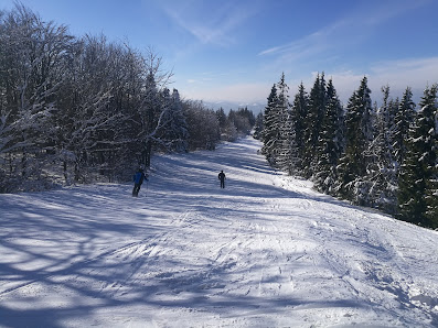 A skier enjoying a day at the Snowparadise Veľká Rača Oščadnica ski resort in Žilina, Slovakia. Features include a charming chalet, a busy ski lift, and a bustling winter sports scene.