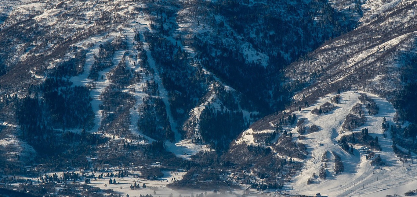 Nordic Valley in USA - a snow covered mountain with trees in the fore.