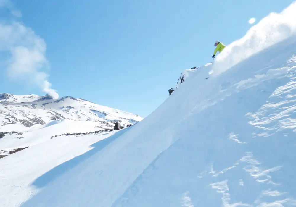 A skier is enjoying their time on the slopes at Caviahue a popular ski resort in Neuquén Argentina. The scene captures a beautiful winter sports activity with mountains in the background.