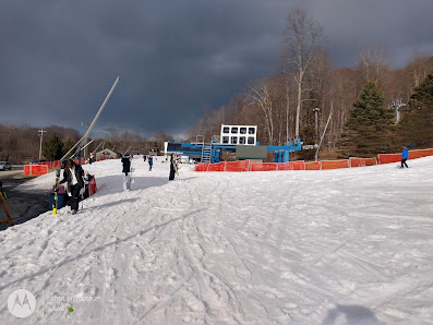 Winter sports scene at Shawnee Mountain in East Stroudsburg, PA with skiers and a ski lift in the snowy landscape of the resort.