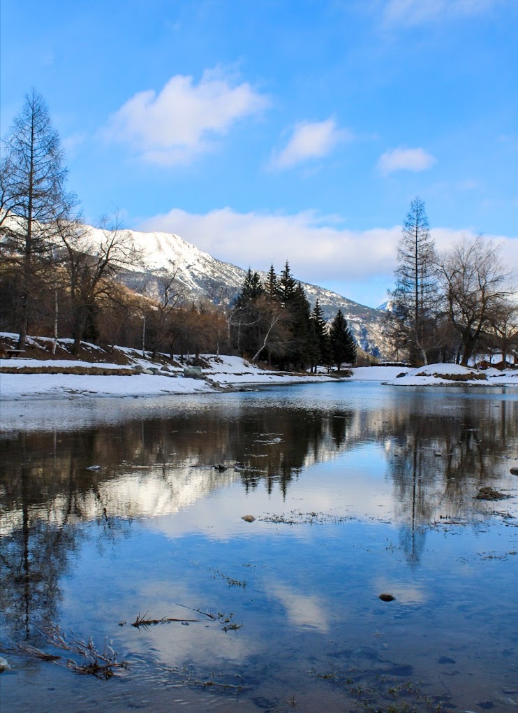Villeneuve (Serre Chevalier) in France - a small lake in the middle of a snowy landscape.