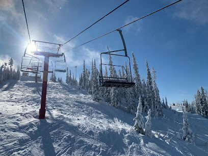 Ski lift and resort on Mount Timothy, British Columbia, filled with winter sports enthusiasts. Snow-covered slopes provide a picturesque backdrop for skiers in motion.