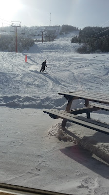 A skier enjoying a winter sports scene at Mount Timothy ski resort in Lac la Hache, British Columbia, Canada, surrounded by snowy landscapes and crisp, fresh air.