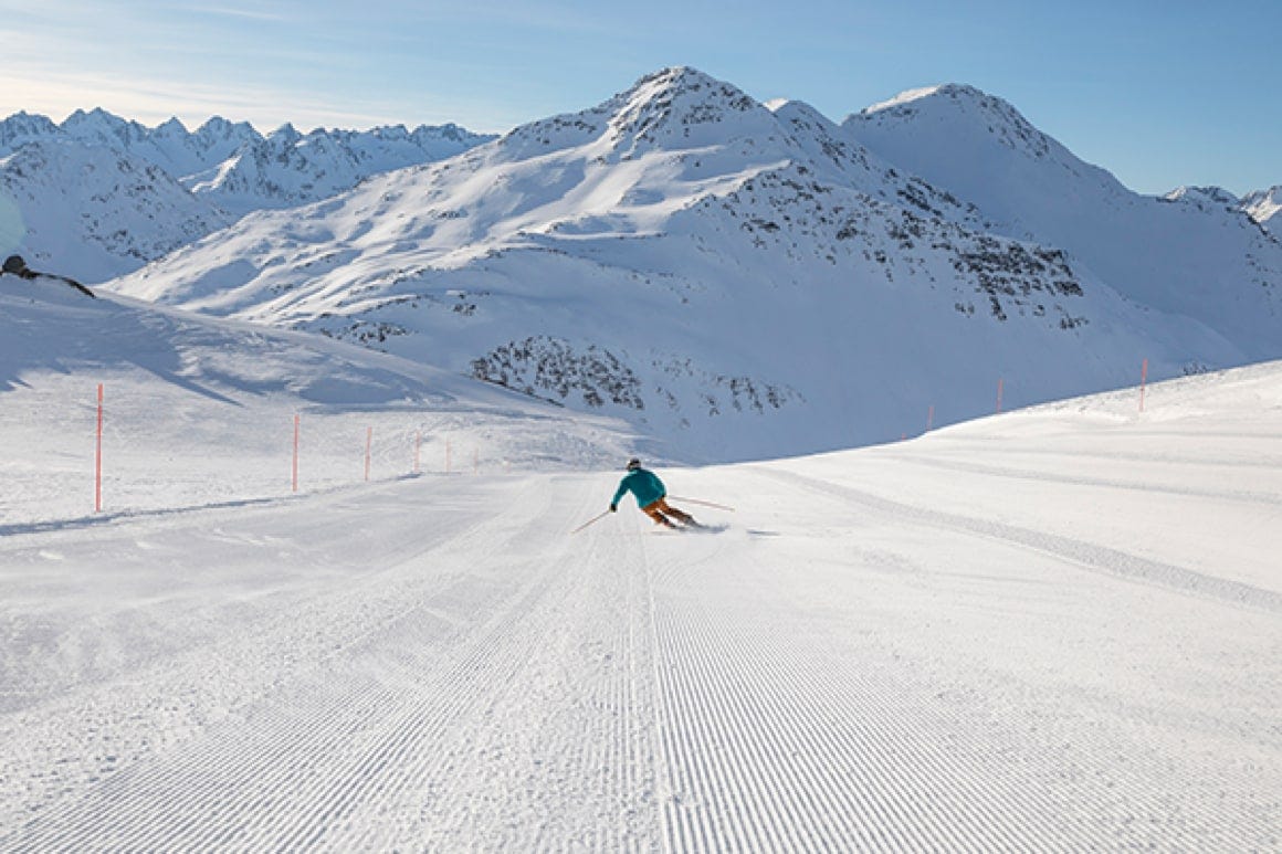Andermatt ​Sedrun Disentis in Switzerland - a person skiing down a snow covered mountain.