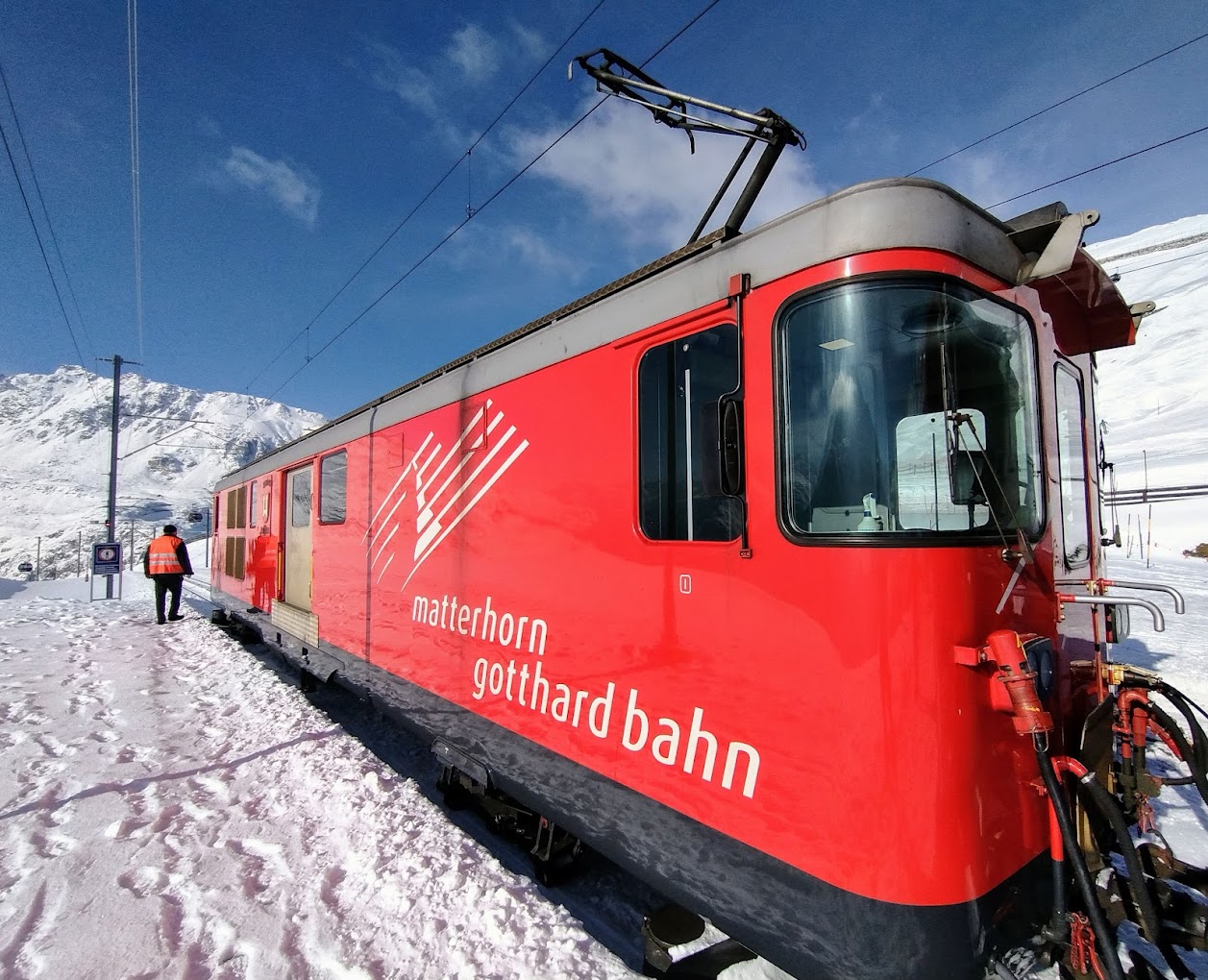 Andermatt ​Sedrun Disentis in Switzerland - the train is red and white.