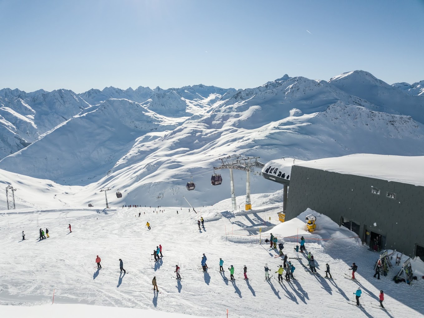 Andermatt ​Sedrun Disentis in Switzerland - a group of people skiing down a snowy slope.