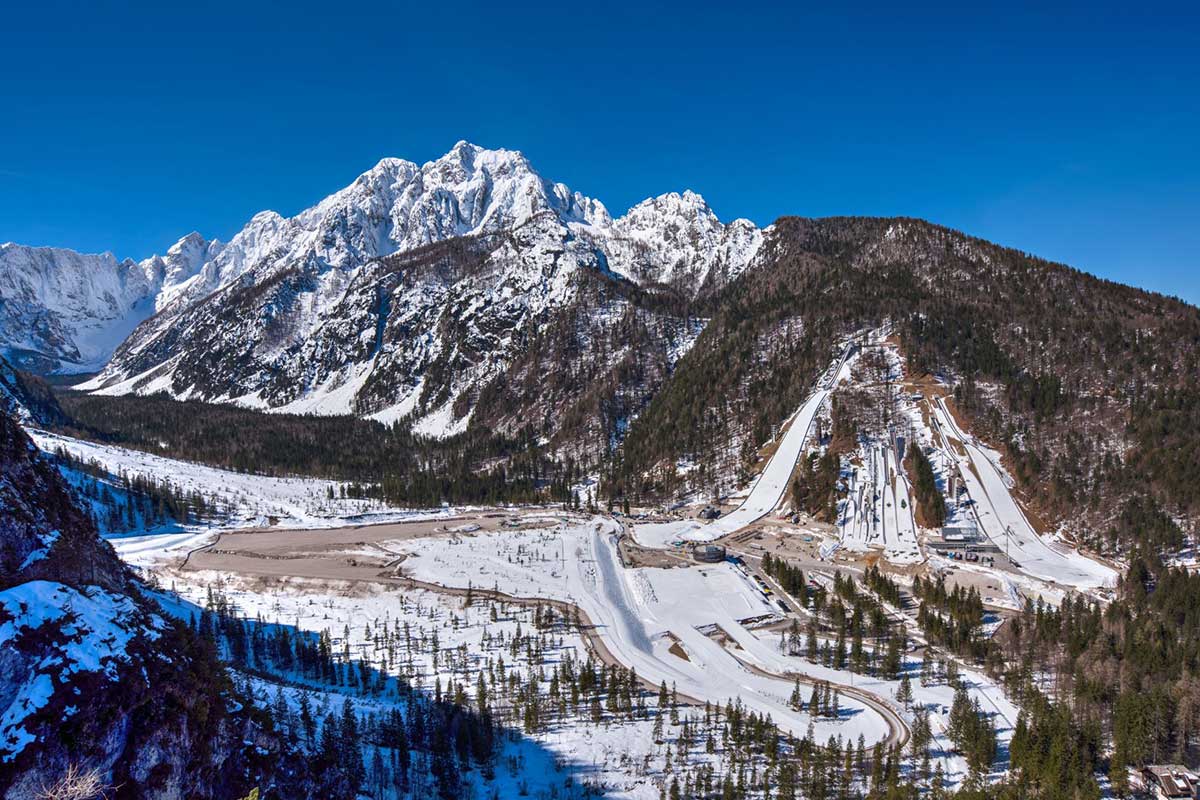 Kranjska Gora in Slovenia - a snow covered mountain with a road running through it.