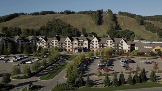 Breathtaking view of Boyne Mountain ski resort in Boyne Falls, Michigan, featuring the majestic mountain and a lodge. A ski lift hints at the winter activities the resort offers.