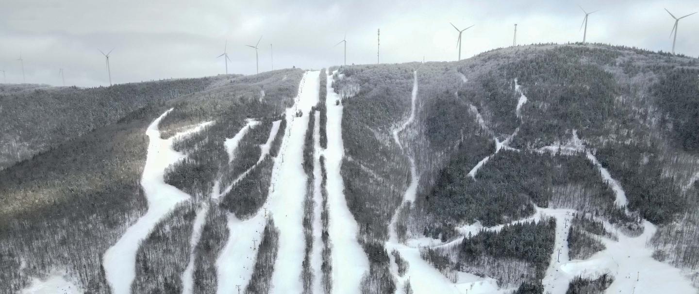 Bigrock Mountain in USA - a snow covered mountain with wind turbines in the background.