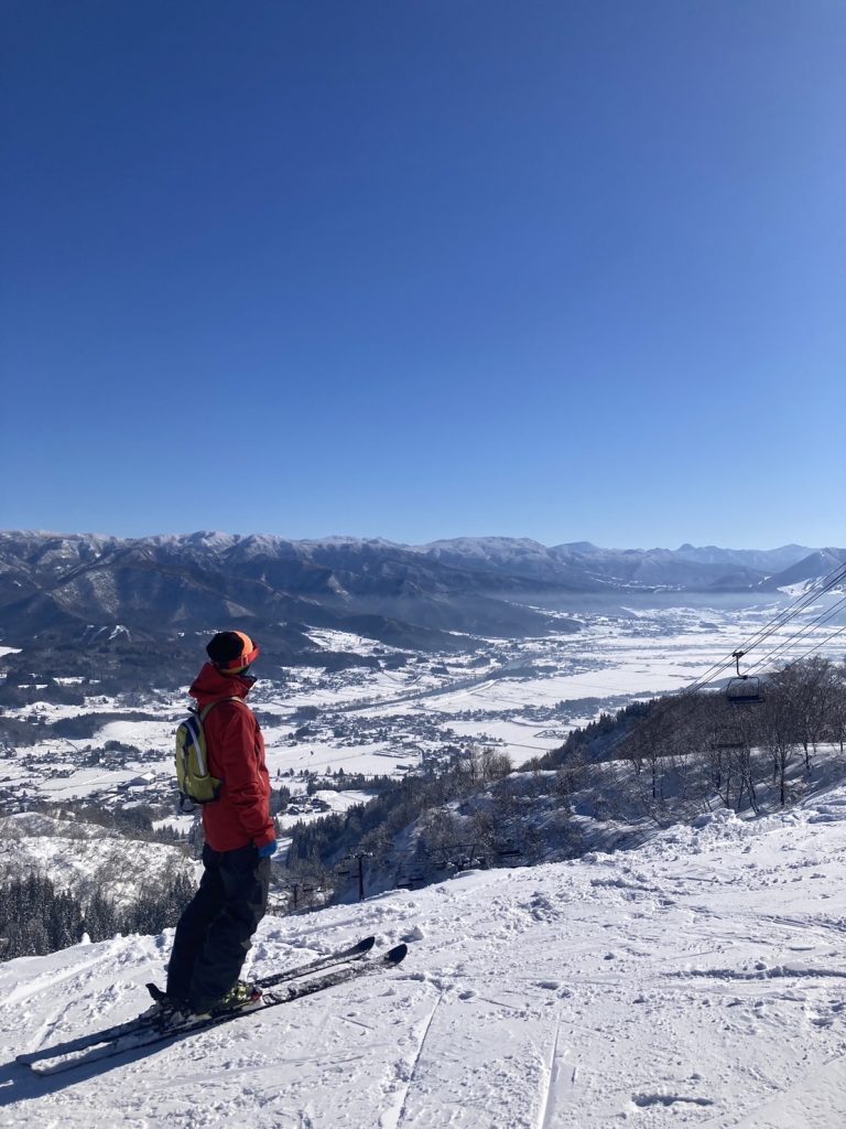 Togari Onsen in Japan - a person standing on top of a snow covered mountain.